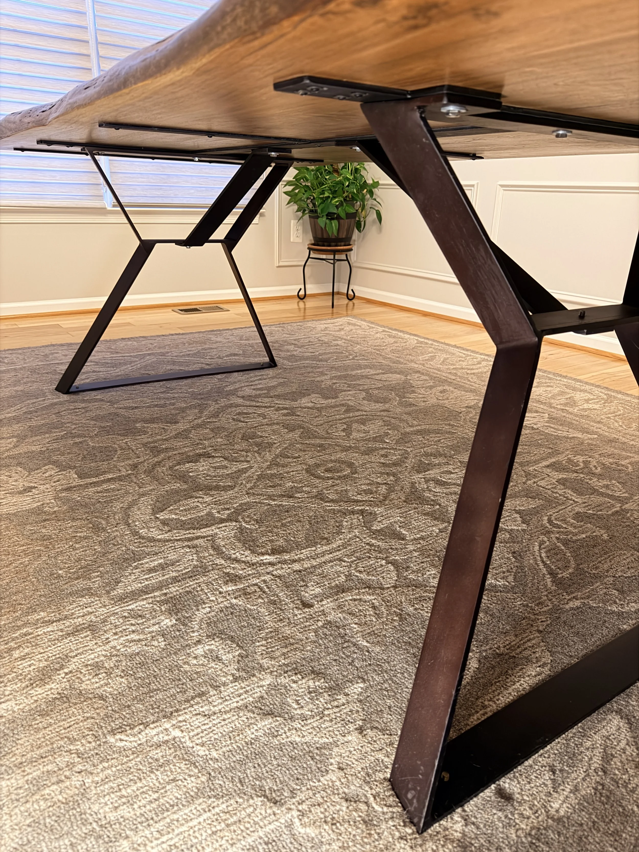 Elegant living room with dark blue paneled walls, wooden accents, chandelier, and plush seating including a navy sofa, cream armchairs, and decorative pillows. A marble and wood coffee table is in the center, and lamps and art pieces are positioned around the room.