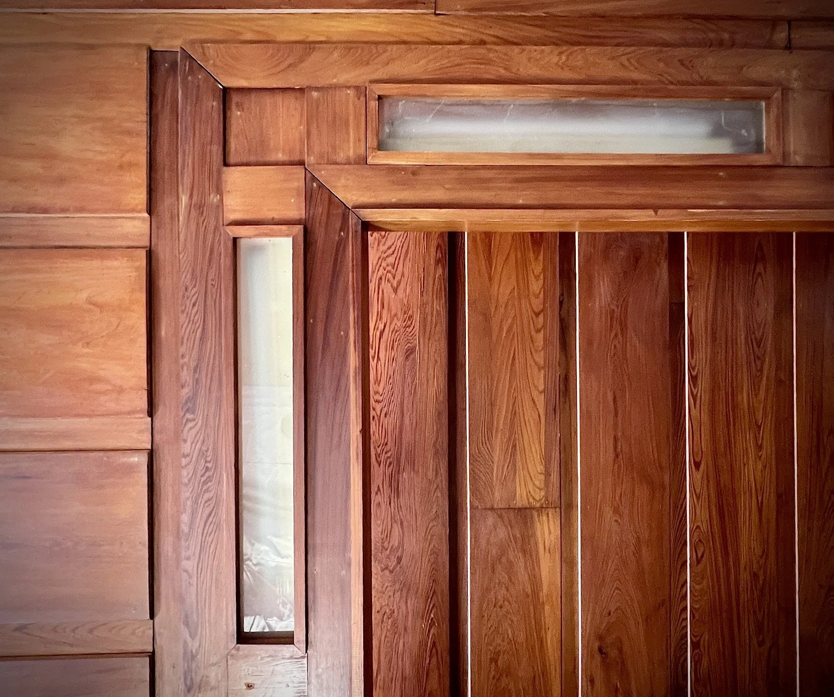 Close-up of a wooden ceiling with a rectangular glass panel.