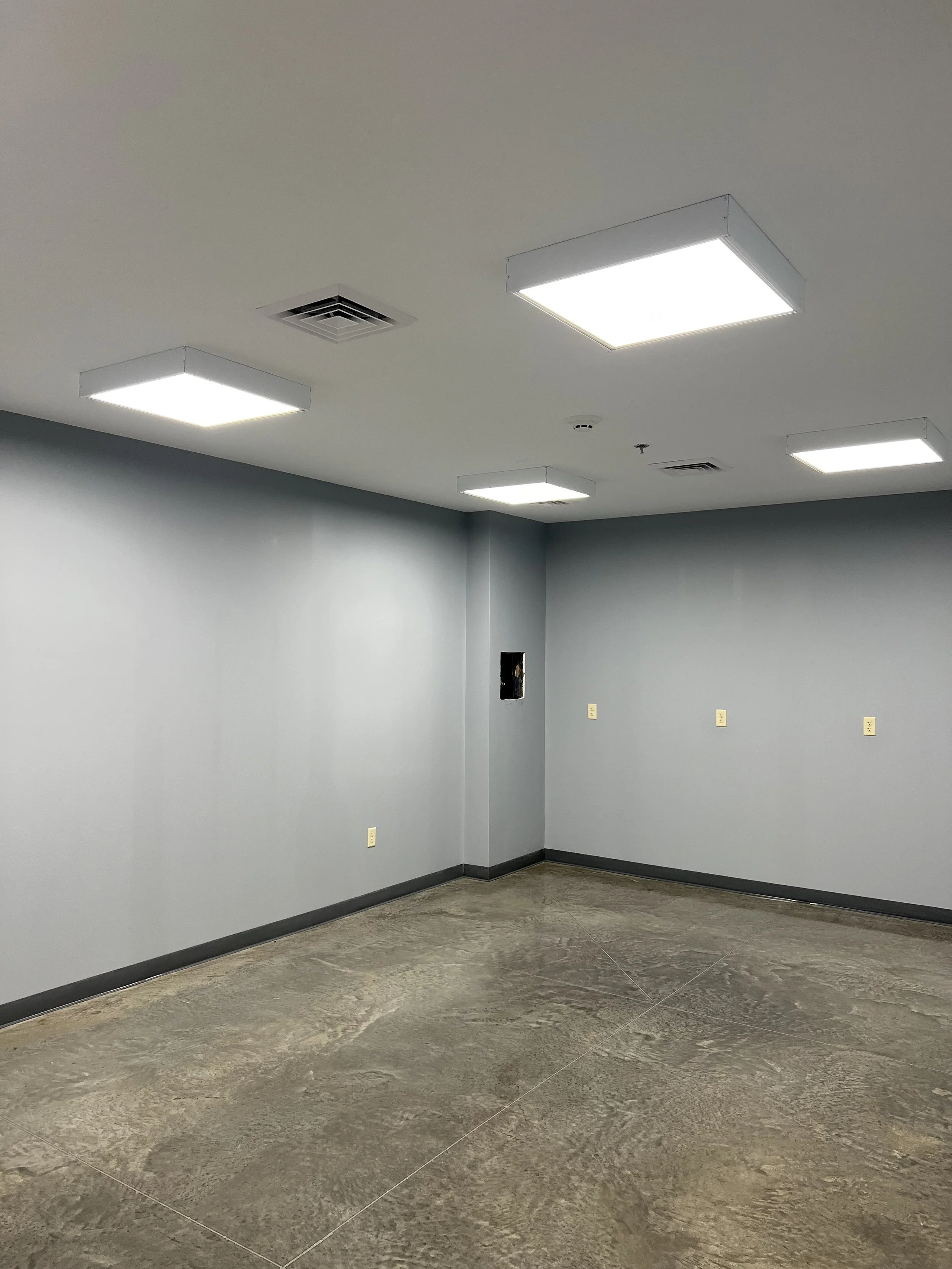 Empty room with gray walls and ceiling lights