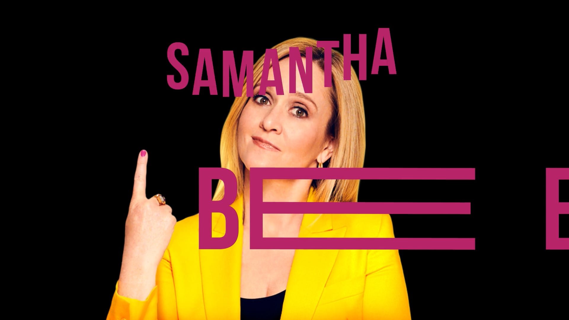 A woman with shoulder-length blonde hair, wearing a yellow blazer and a black top, is pointing her index finger upward. She has pink nail polish and a ring on her finger. Text over her head reads 'SAMANTHA' in purple, and there is a partial text 'BE' in purple over her chest.