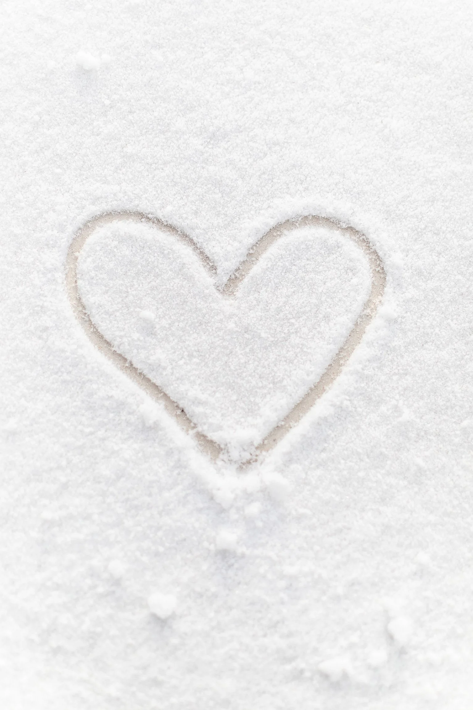 A heart shape is drawn in the snow.