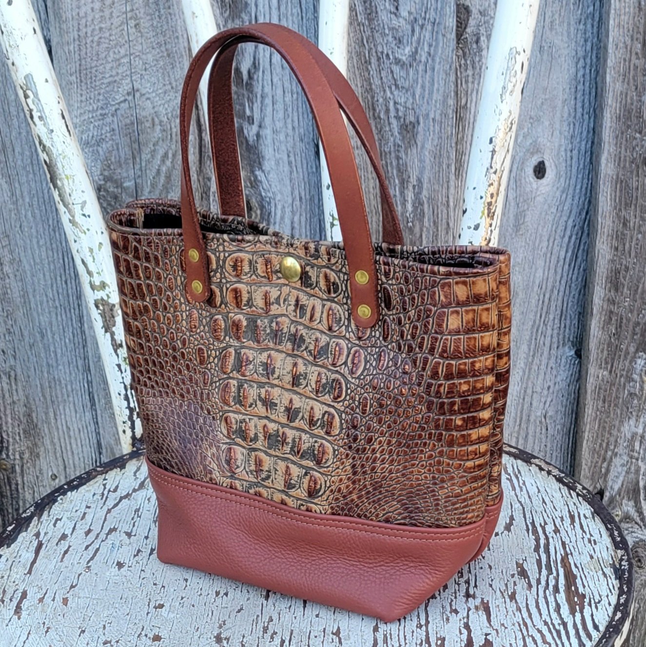 Two tone leather is complimented by water buffalo straps on this mini tote