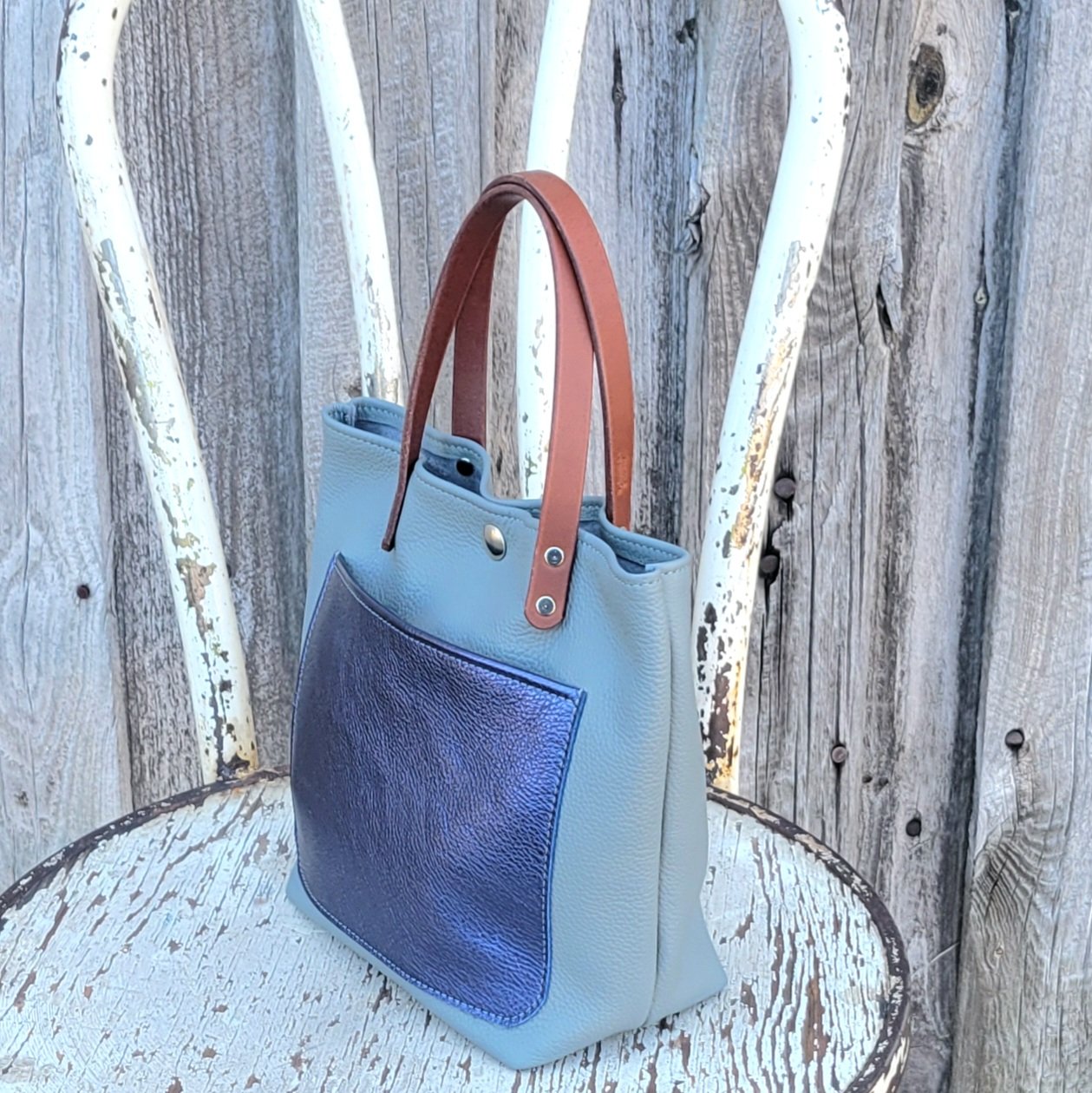The leather of this mini tote bag is pebbled and soft in temper
