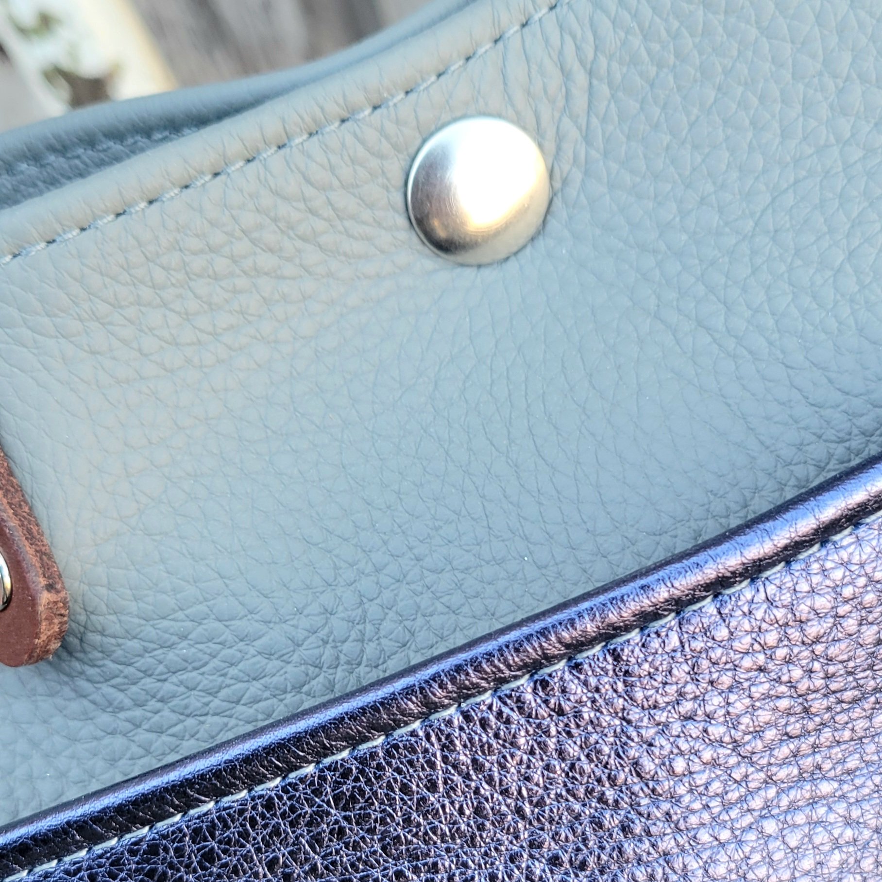 Hemmed edges on a leather mini tote bag provide refinement