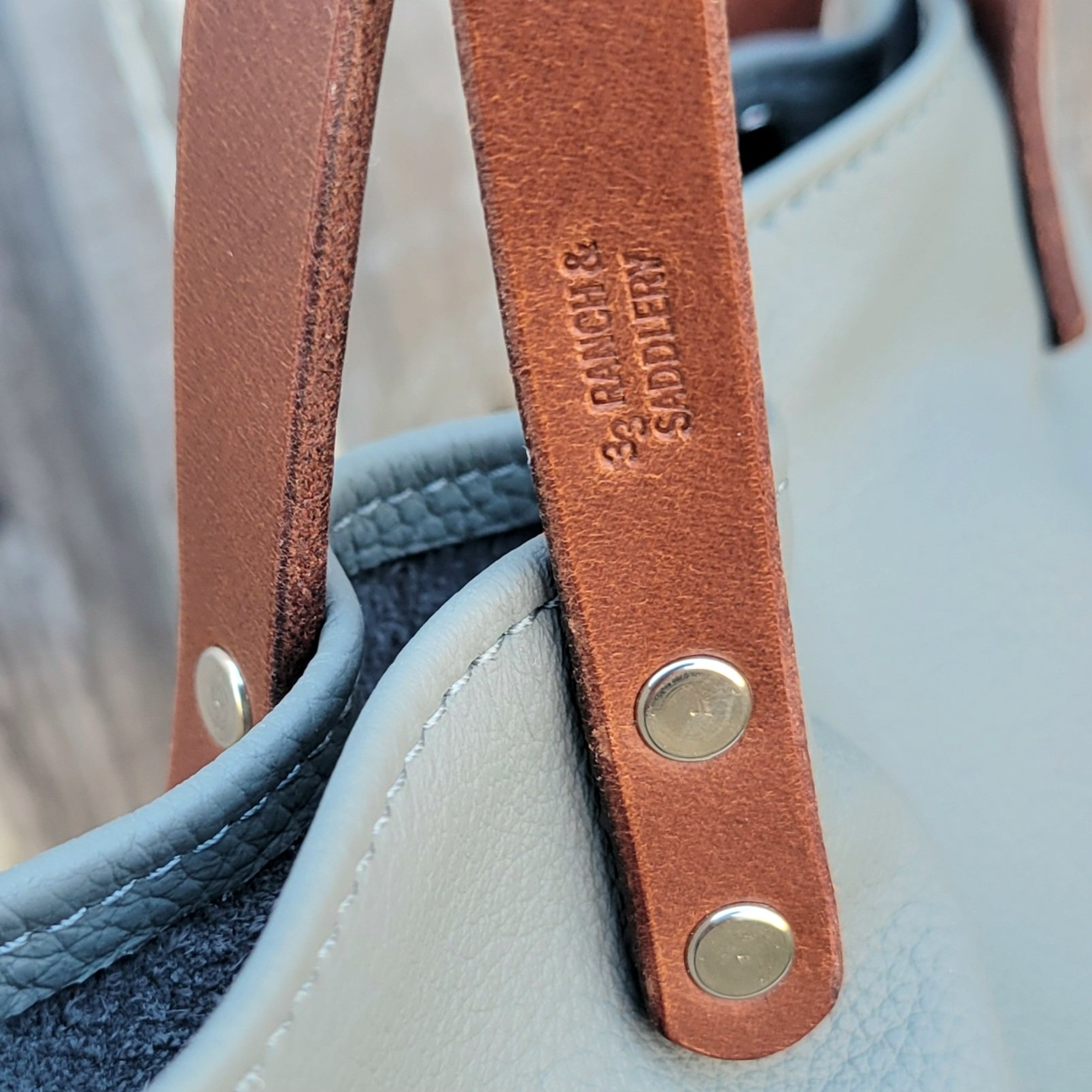 Maker mark on the strap of a mini leather tote bag