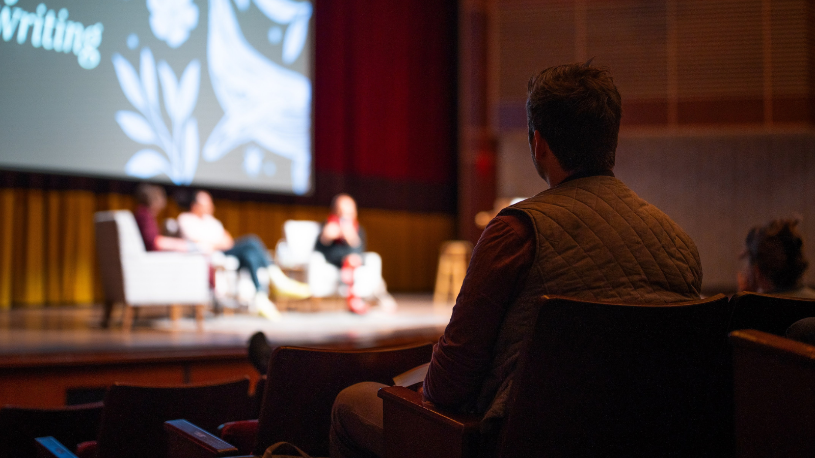 Audience member listening to authors on the Festival stage.