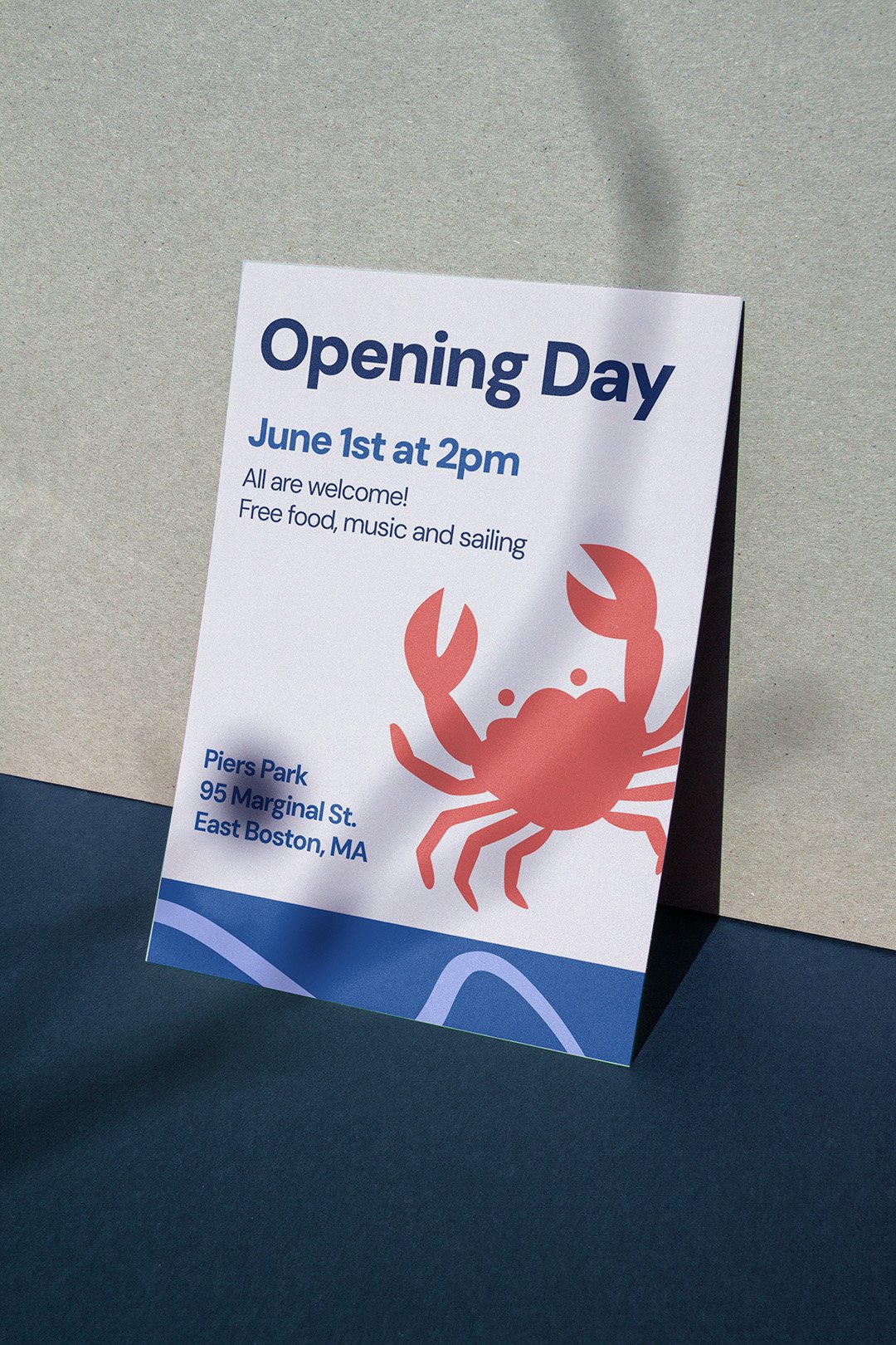 A printed flyer balancing against a wall that has details for an upcoming open day and a big illustration of a crab