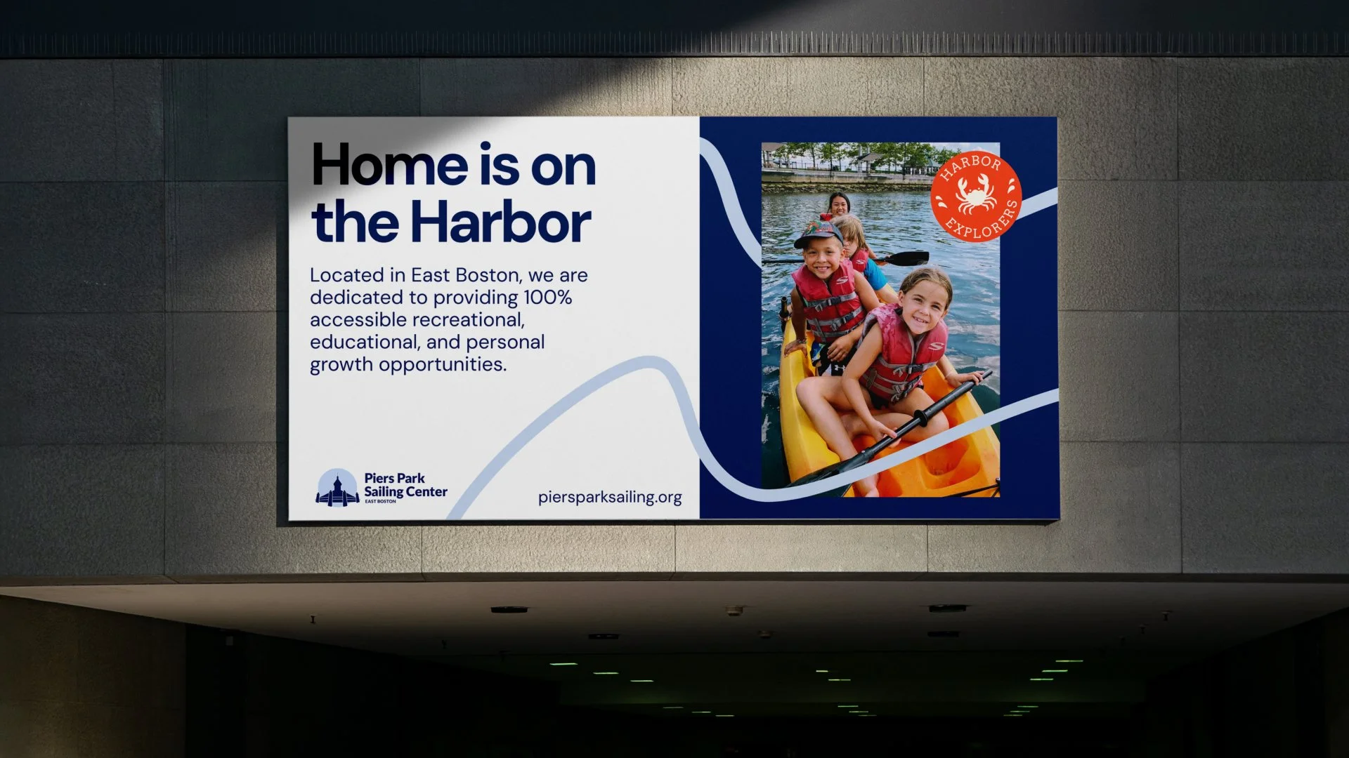A billboard saying 'Home is on the Harbor' and a picture of children kayaking