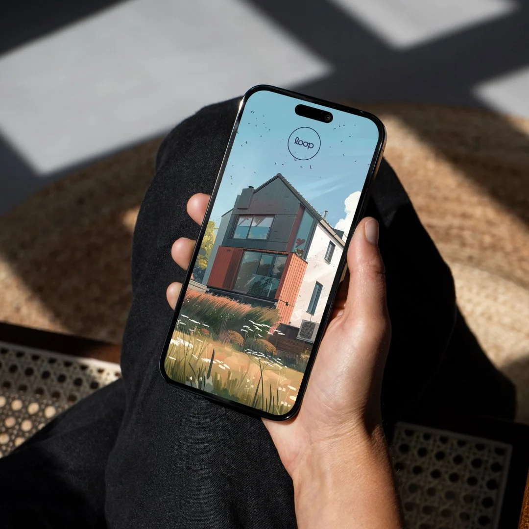 A hand holding a phone with the logo on screen