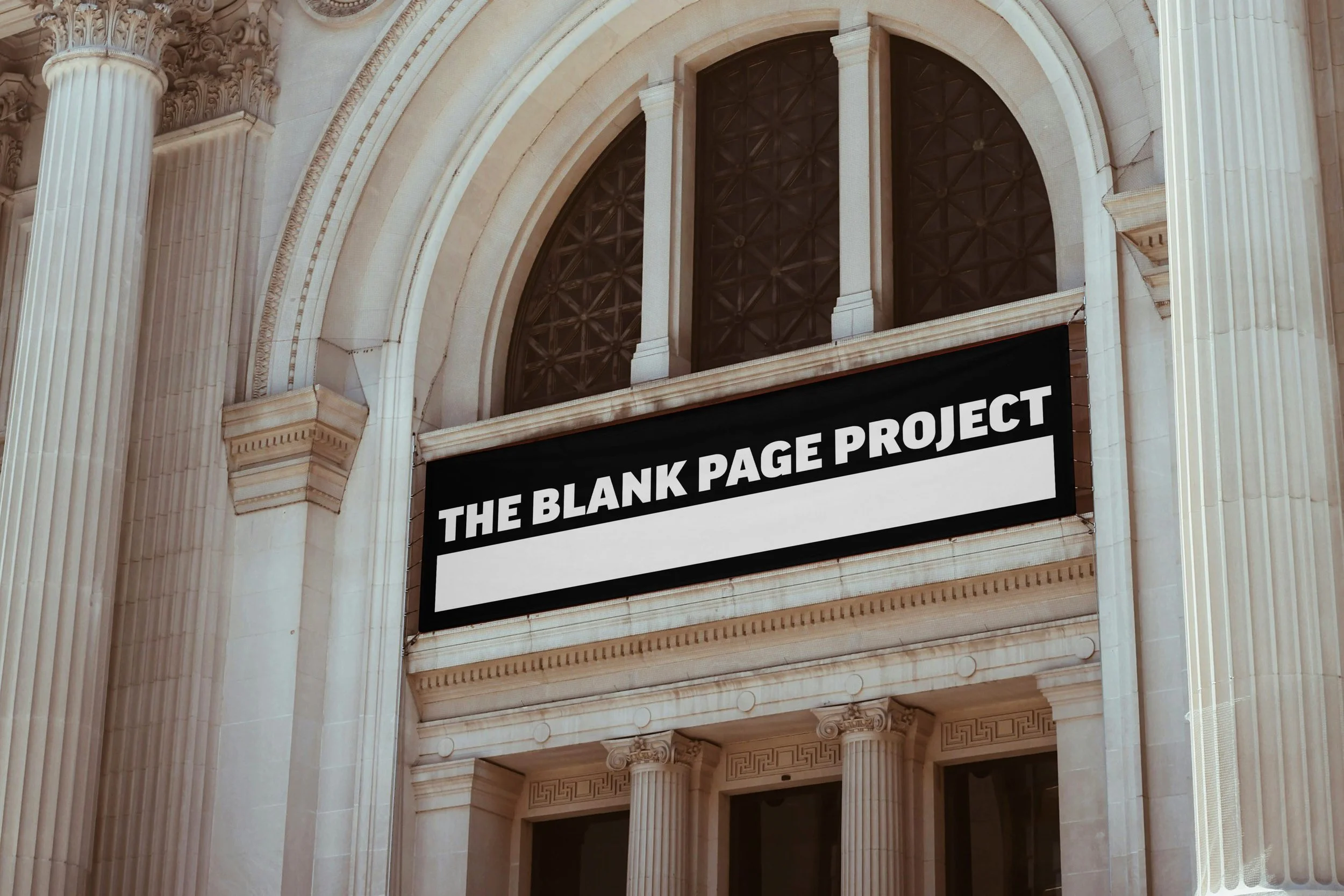 Large outdoor billboard for The Blank Page Project mounted on a classical stone building that looks like a library