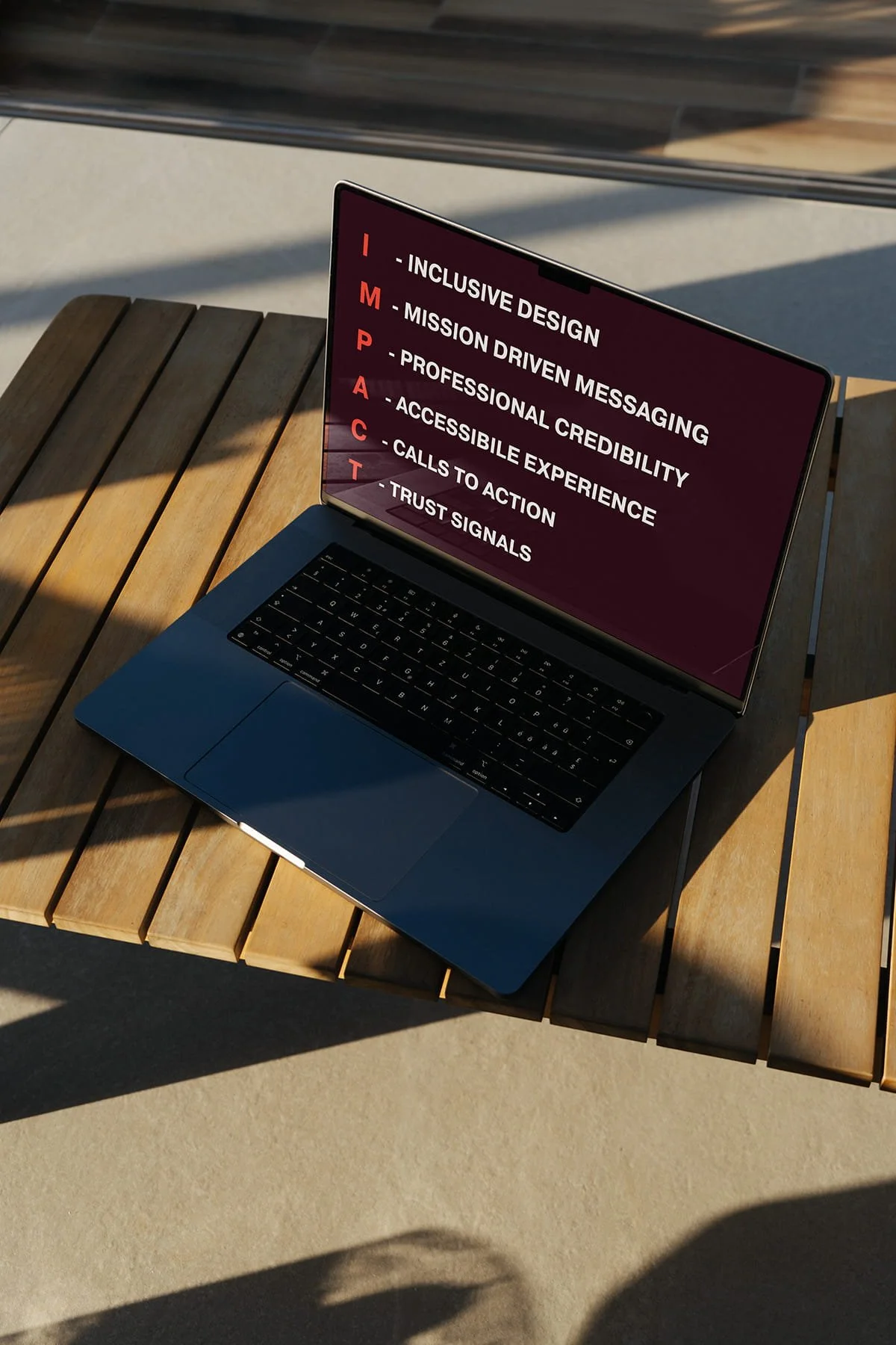 A laptop with the IMPACT acronym on screen spelling out Inclusion, Mission Driven Messaging, Professional Credibility, Accessible Experience, Calls to Action, Trust Signals
