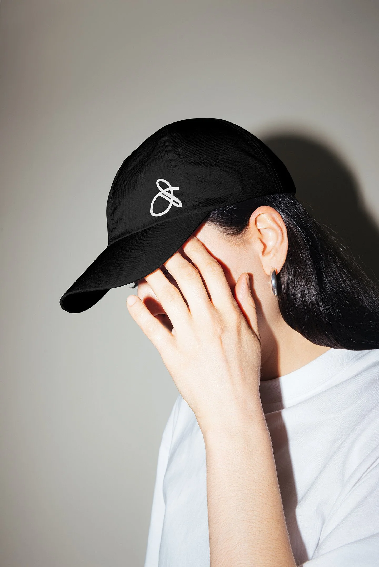 A woman wearing a baseball cap with the Drift and Design logo printed on it
