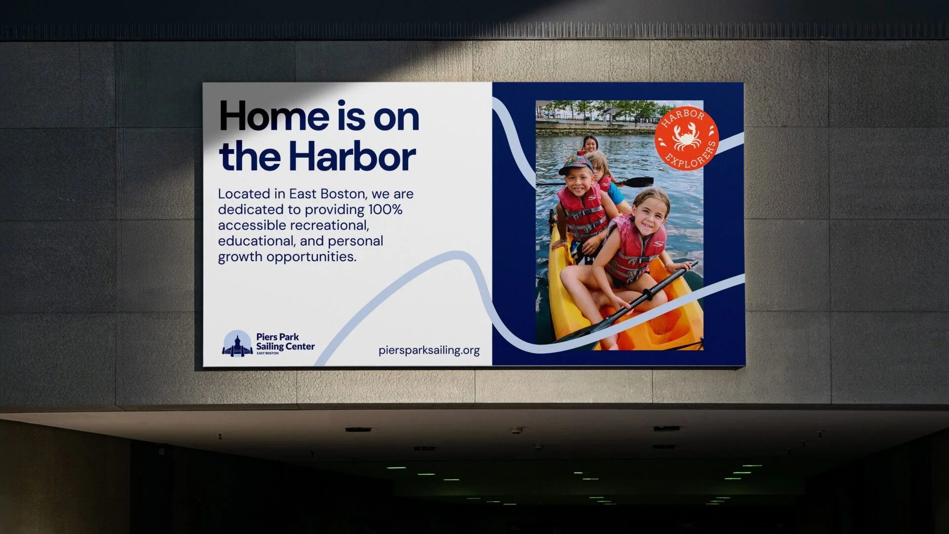A billboard mock up with details of the sailing centre and a photo of four people in a kayak looking at the camera and smiling