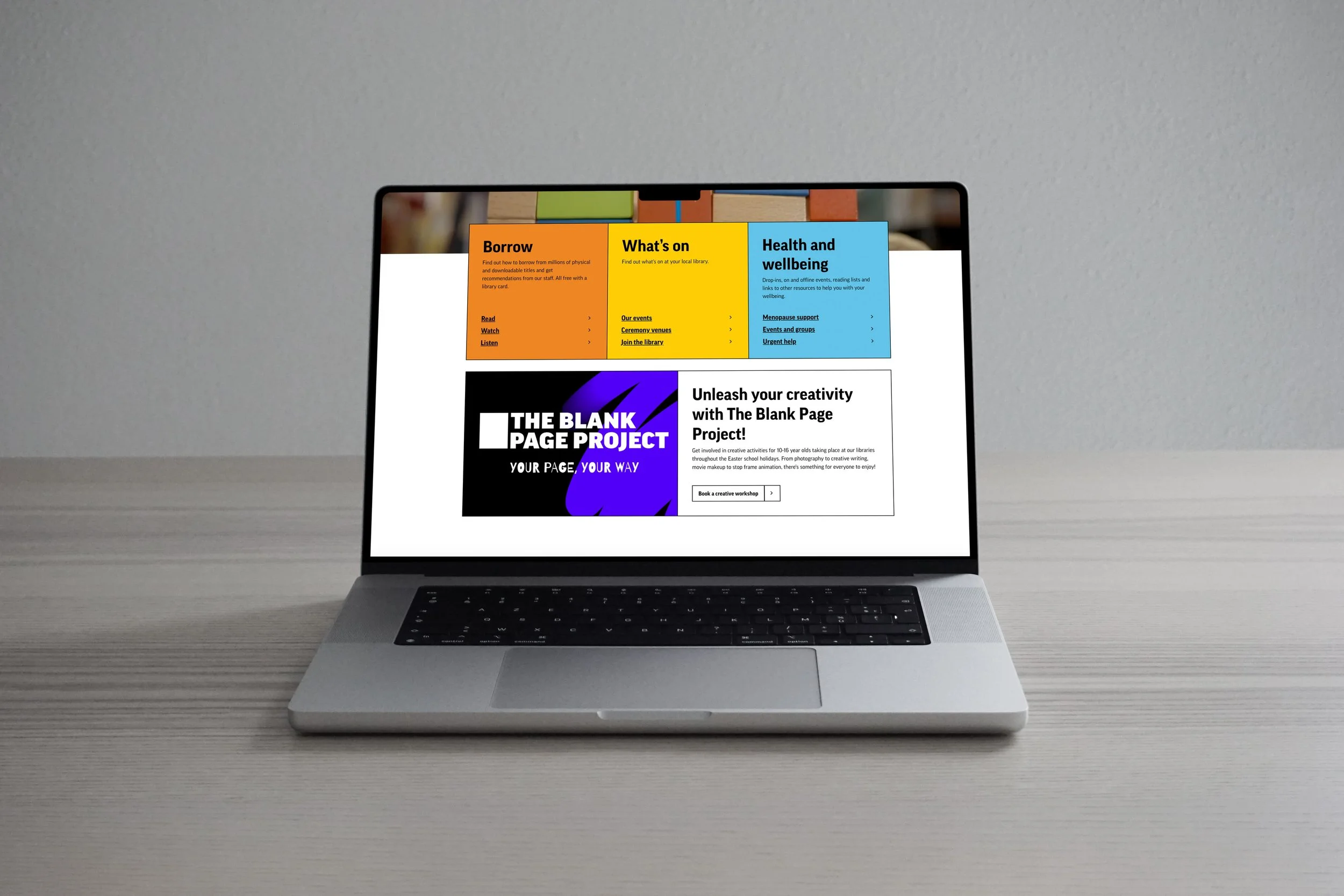 Laptop mockup displaying a webpage for The Blank Page Project, featuring a bold purple graphic banner, promotional text encouraging creativity, and colourful navigation panels for library services and events.