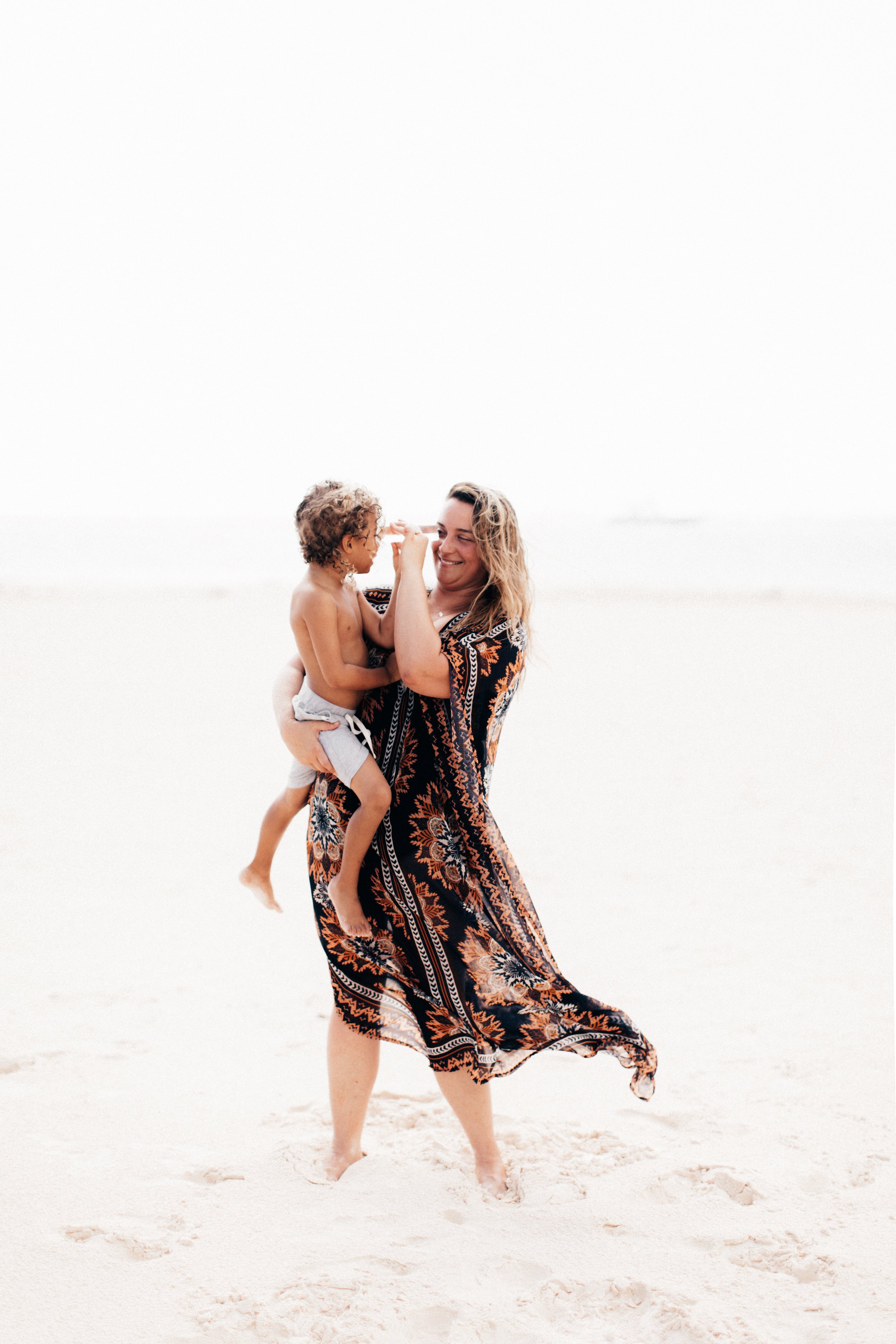 Hannah Freeman holding her son in a white beach