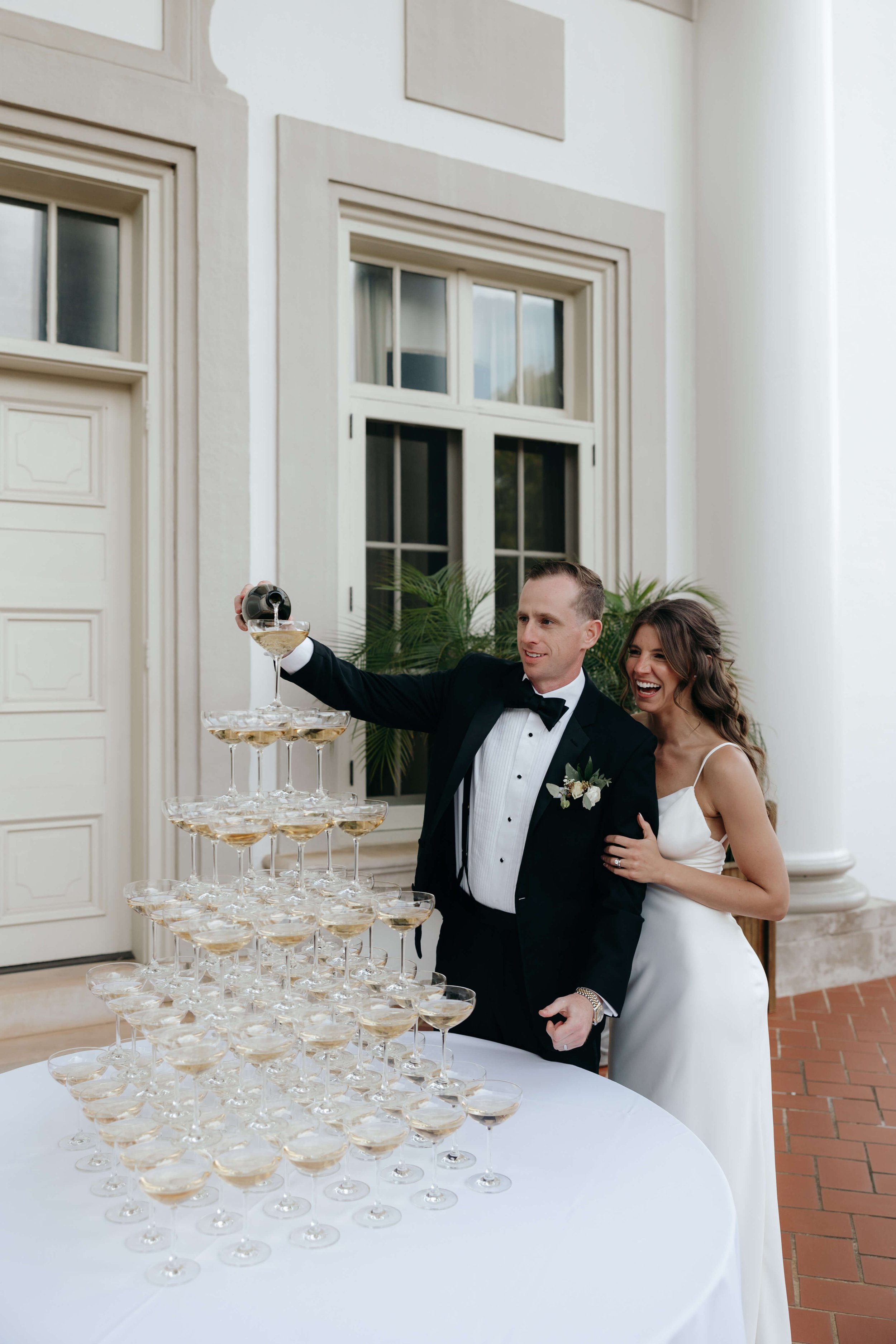 Couple pour champagne on champagne tower