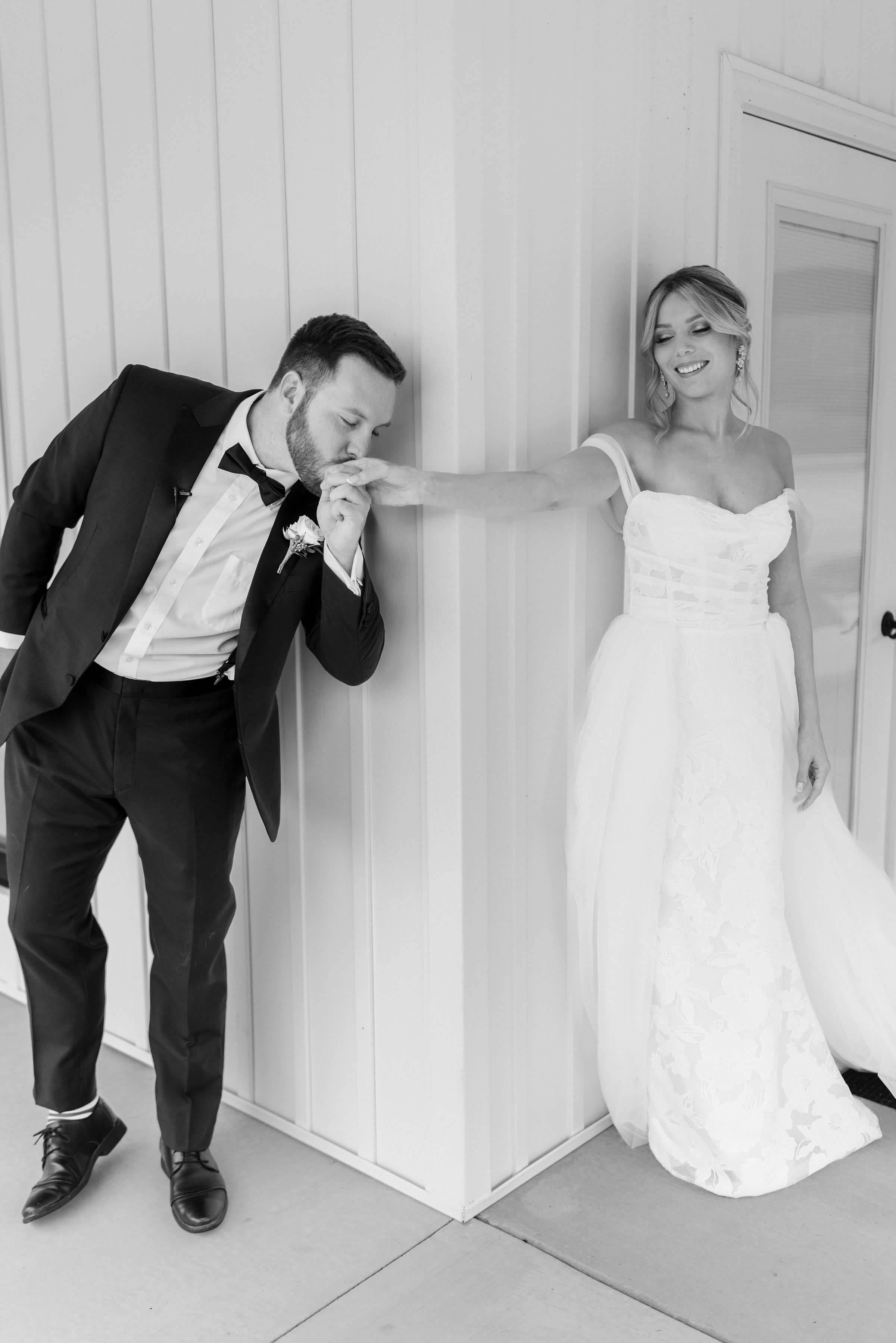 Broom kissing bride's hand