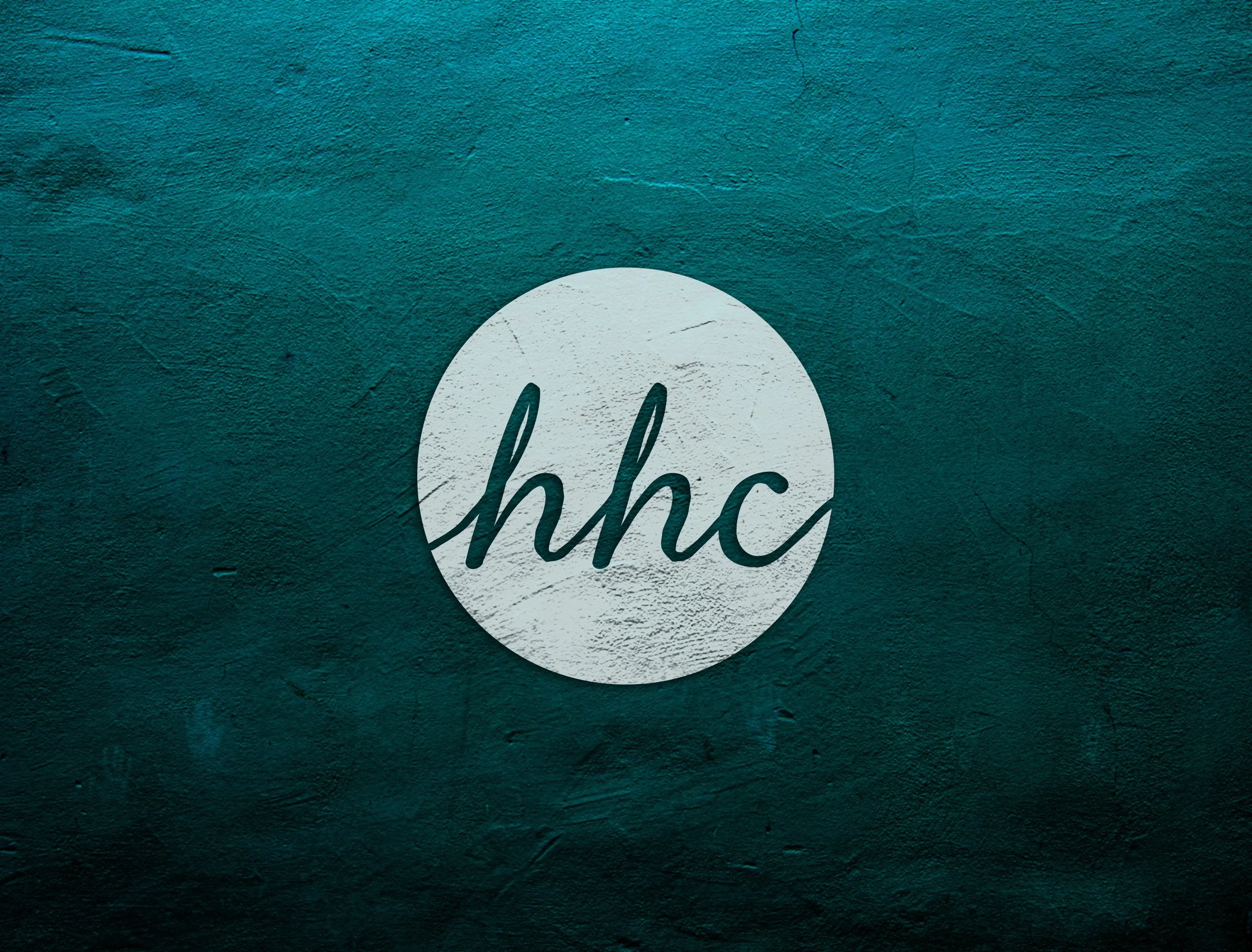 HHC Circle Icon logo on teal background wall texture.jpg