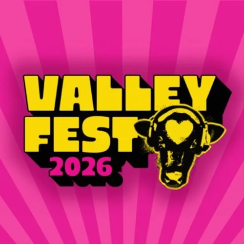 Bright pink background with radiating lines, featuring the text 'Valley Fest 2026' in bold yellow with a black shadow, and a yellow and black stylized animal head resembling a cow. Where you can find ONFIRE AND RESCUED FIRE TRUCK