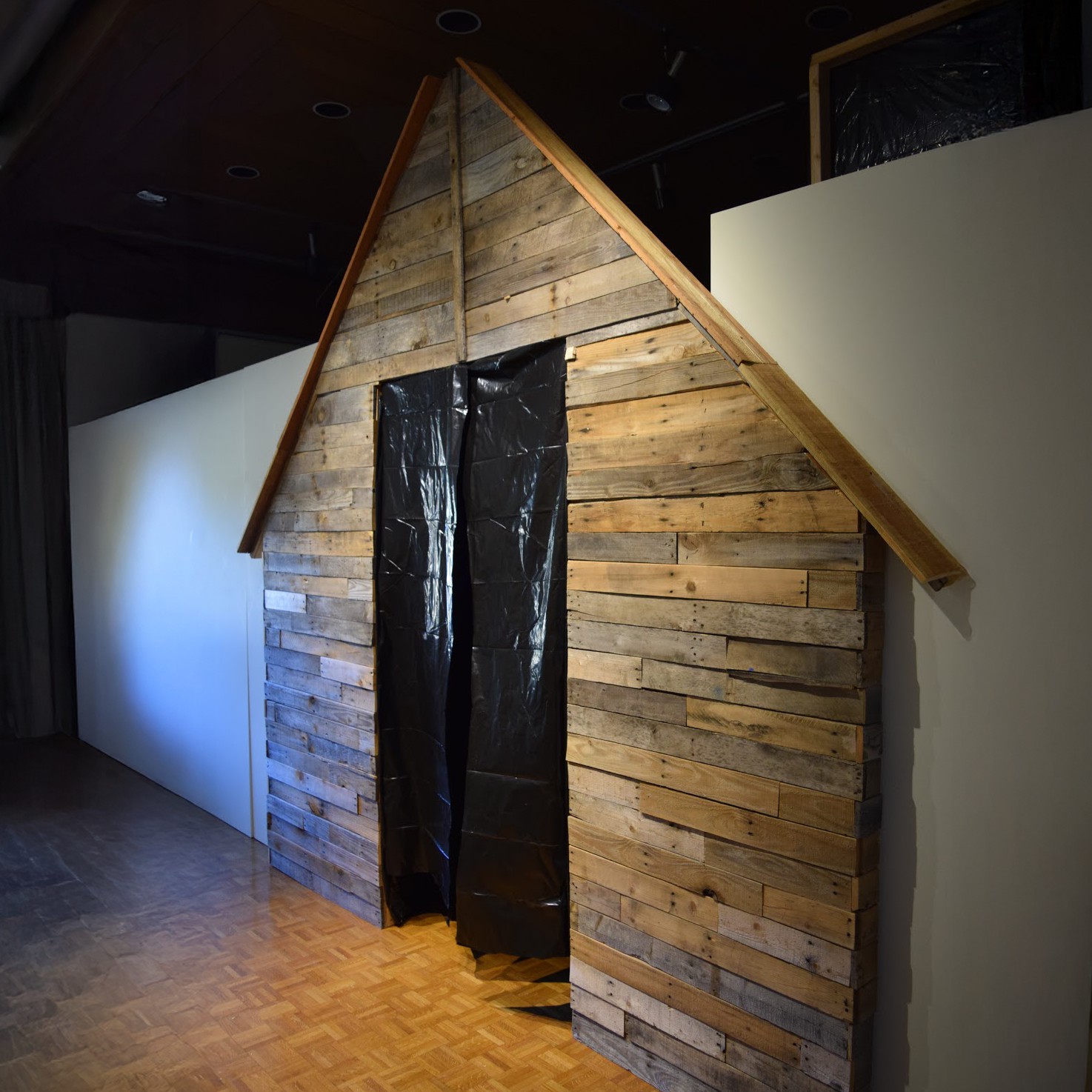 Cabin facade made of pallet wood stading in an art gallery