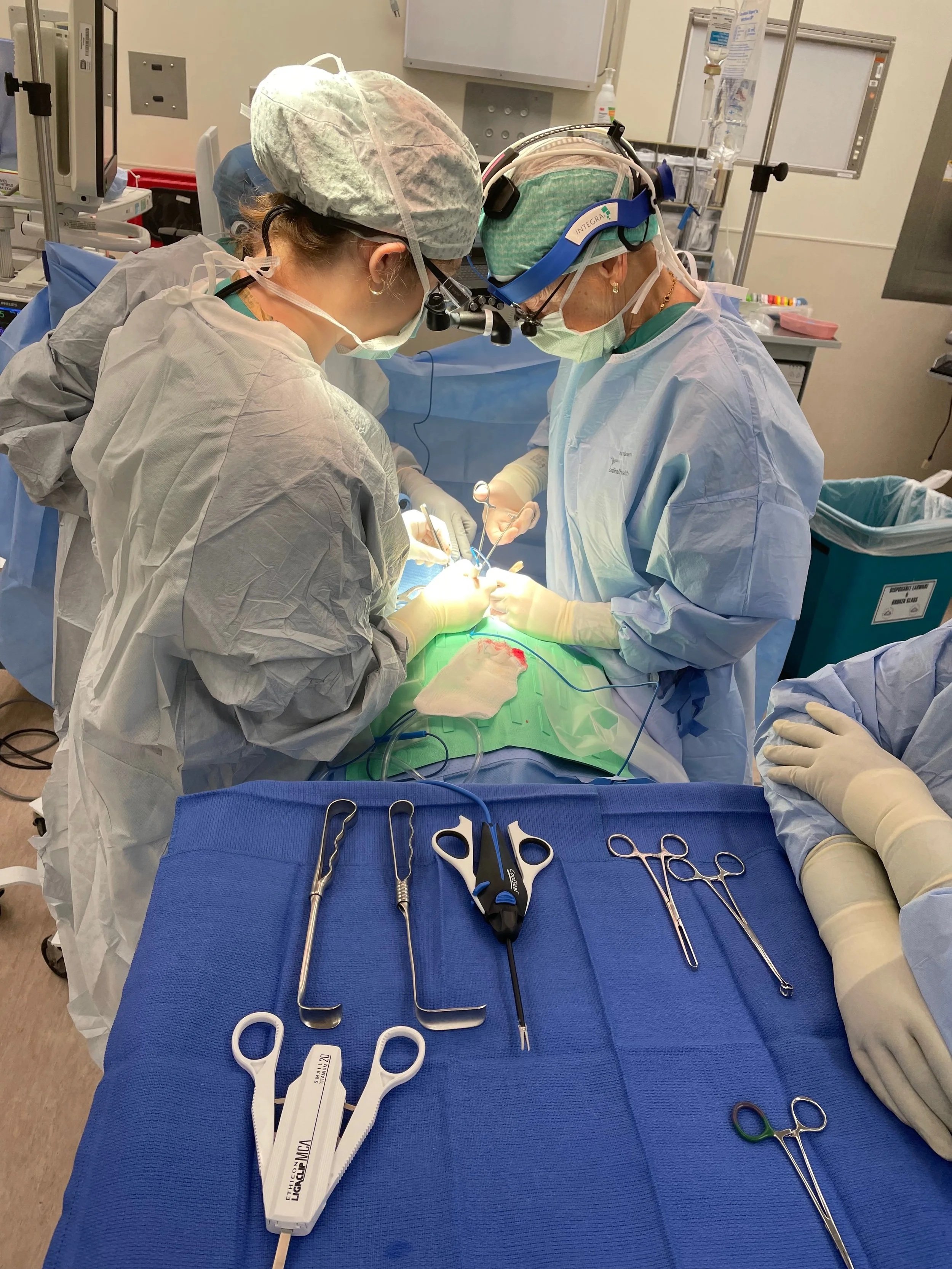 Dr. Martha Zeiger performing an operation in an operating room, with surgical tools laid out on a blue sterile cloth.