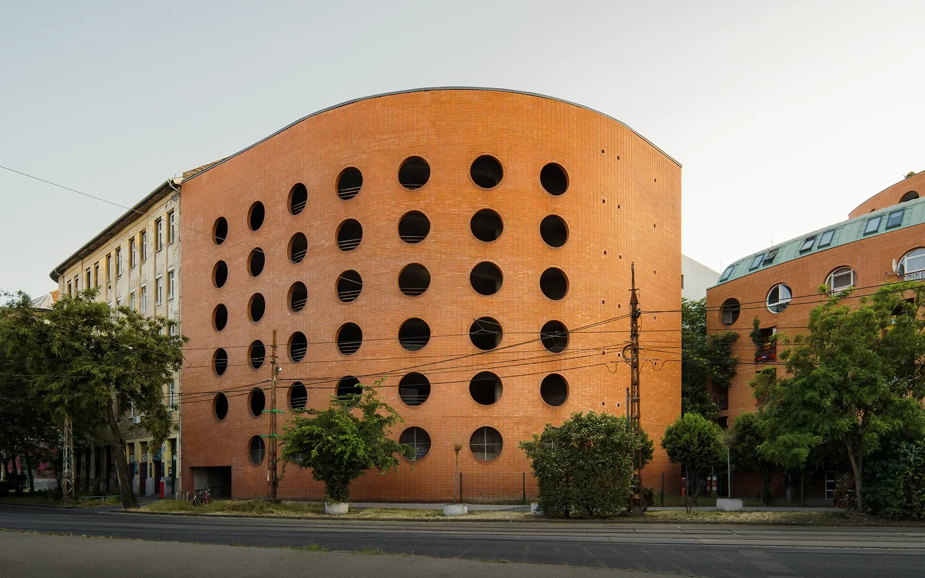 Side view of Orczy Tér Budapest curved apartment block with circular parking openings