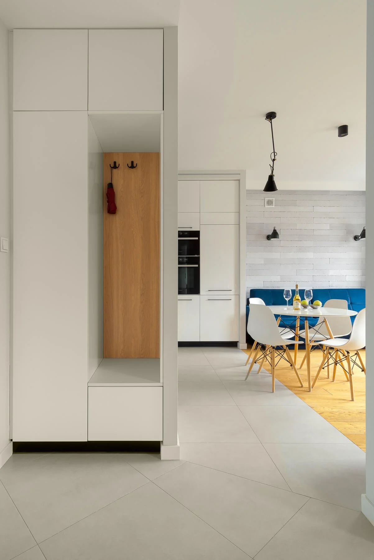 Modern hallway from a house that open inspiration a with table, lights, ceiling, and doors that show the rest.