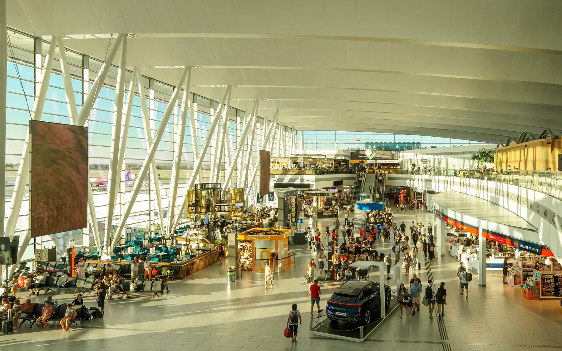 Wide angle shot of Budapest Liszt Ferenc Airport main hall with curved white roof and glass wall