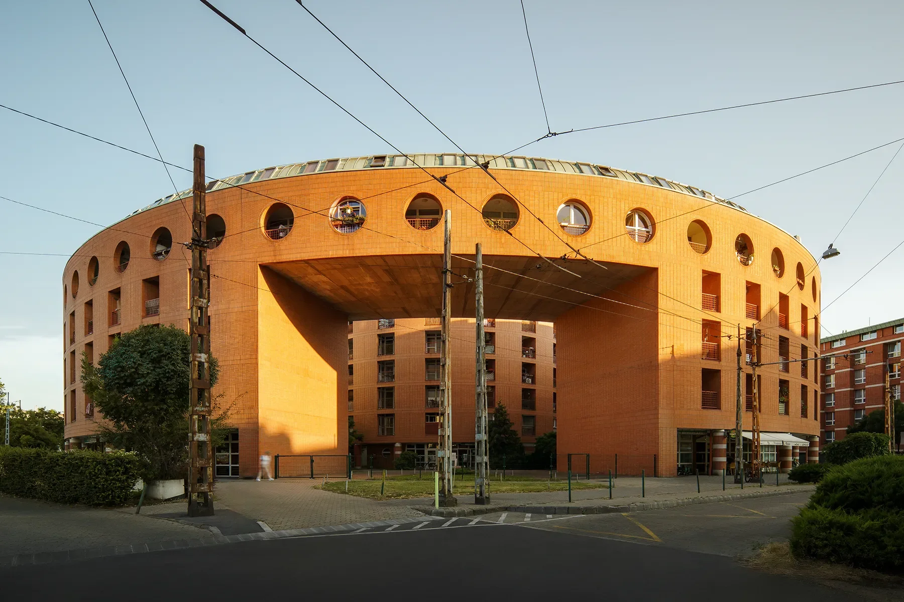 Wide shot of Orczy Tér Budapest main entrance arch with sunset lighting and road