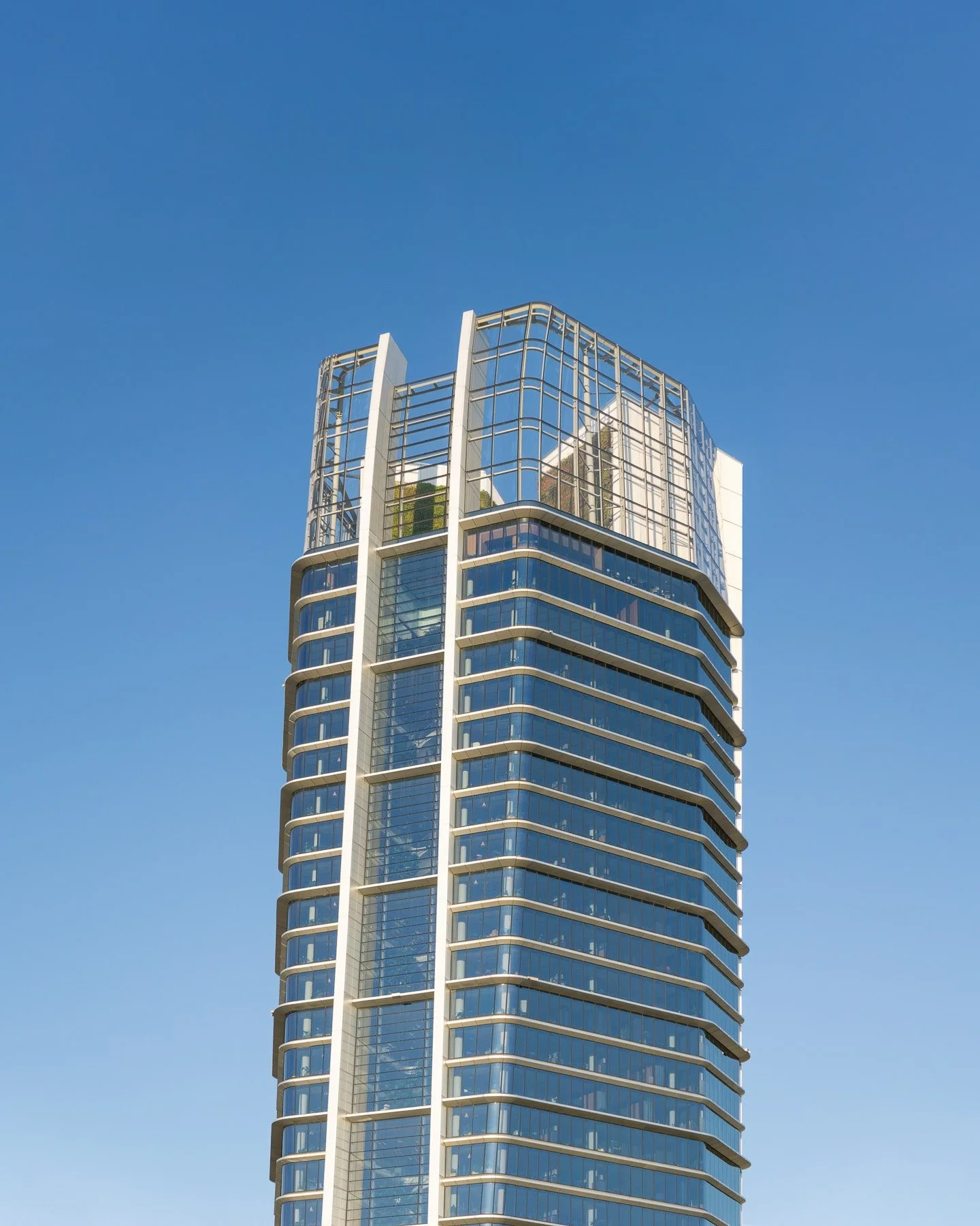 Budapest, Hungary: MOL Campus building featuring a modern geometric design with a striking facade of repeating patterns. Close-up view with a blue sky in the background.