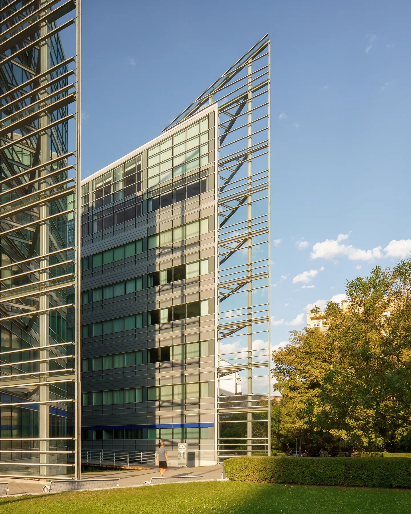 Vertical shot of Alkotás Point Office Budapest with person and surrounding greenery