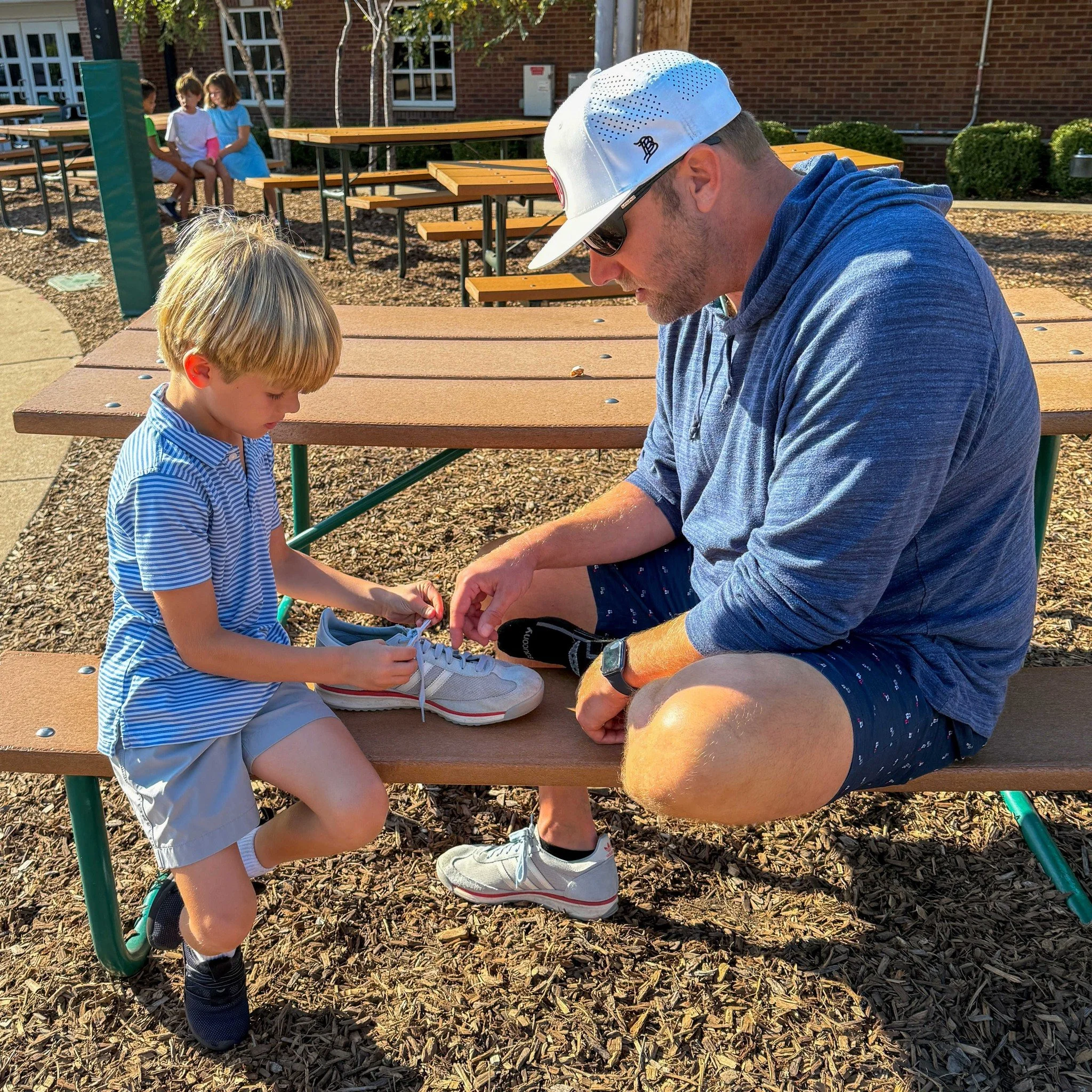 Sometimes the best lessons happen OUTSIDE the classroom! 🔆

Pictured here, Mr. Rick Downs (Grade 1) helps a student learn how to tie HIS shoelaces! 👟