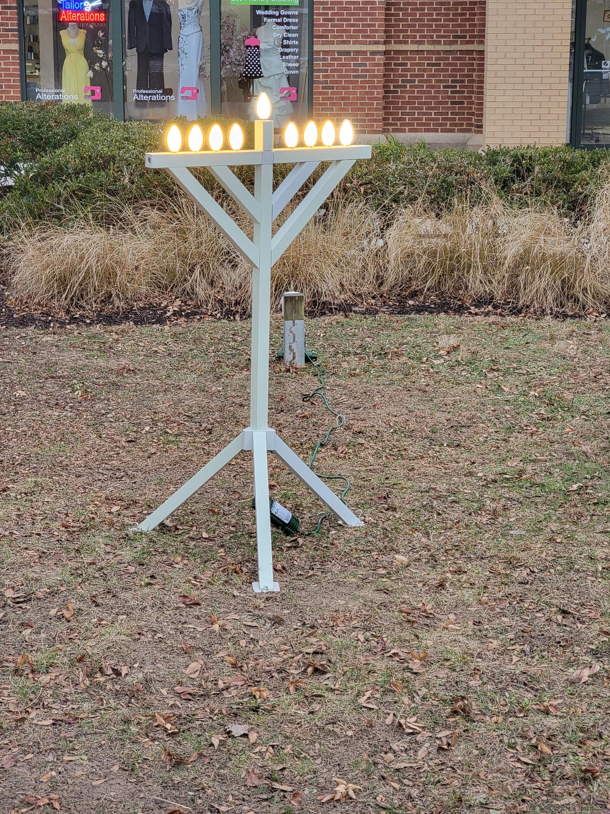 Large lit menorah displayed at the Tree and Menorah Lighting event
