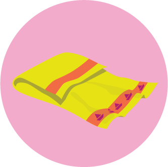 A folded yellow towel with red and purple patterns on a pink background.