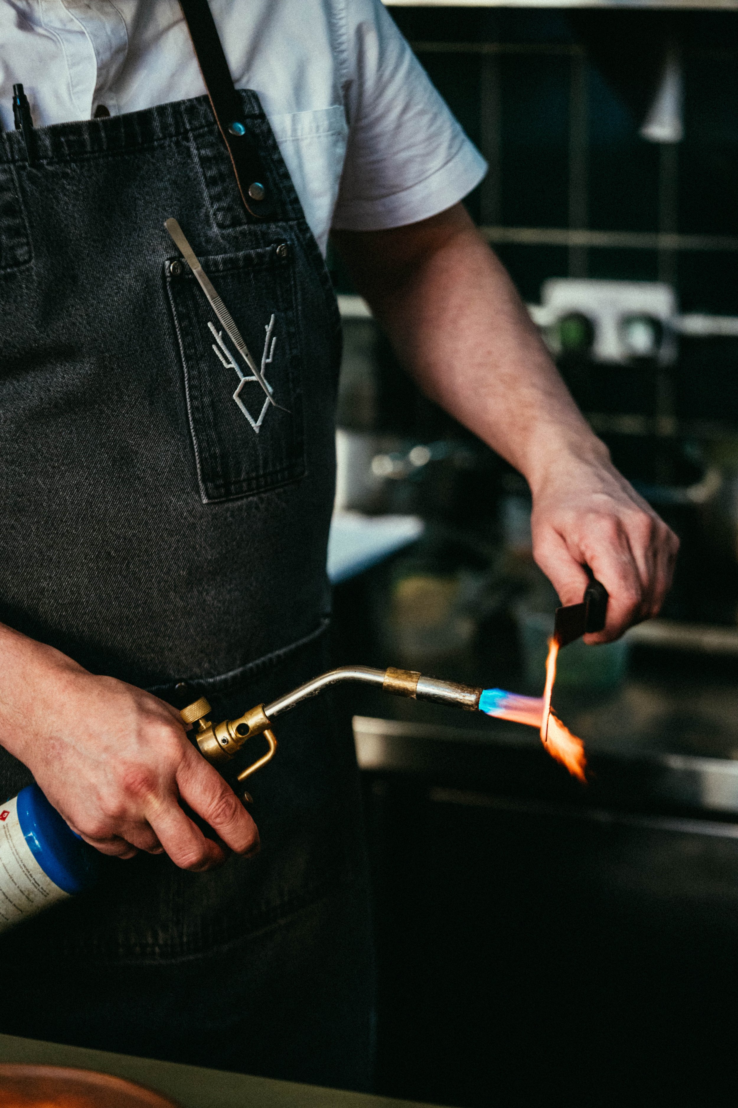 Fallachan Dining - Chef using a blowtorch in a kitchen.