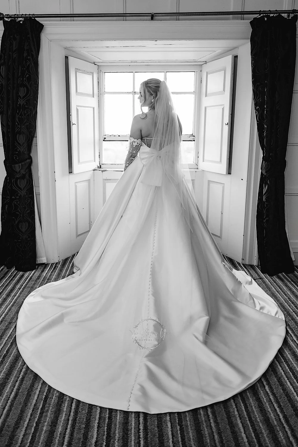 Black and white image of Bride stood in the window at Wortley Hall