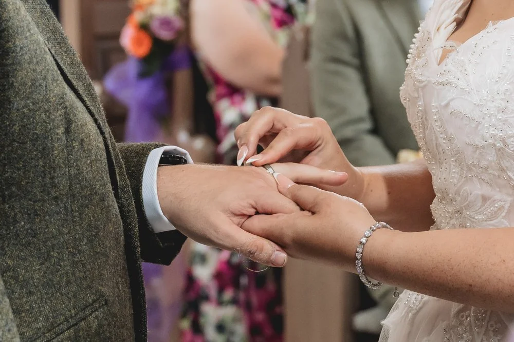 Close up of hands exchanging rings