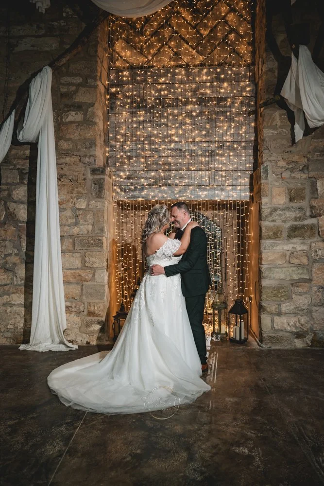 Just married couple in front of a beautiful stone wall