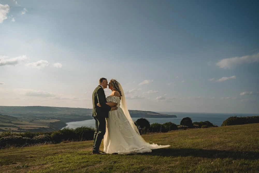 Wedding couple stood by the sea at sunset
