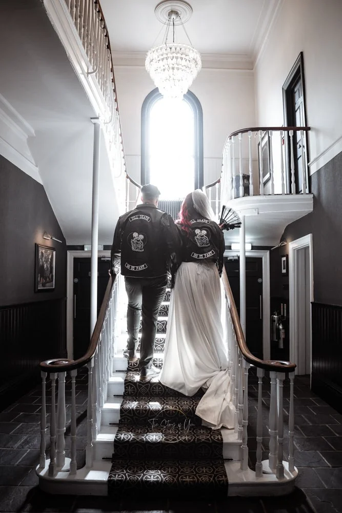 Alternative wedding couple on stairs in leather jacket