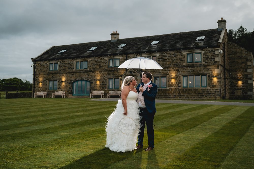 Wedding couple in the rain standing in front of a luxury yorkshire venue