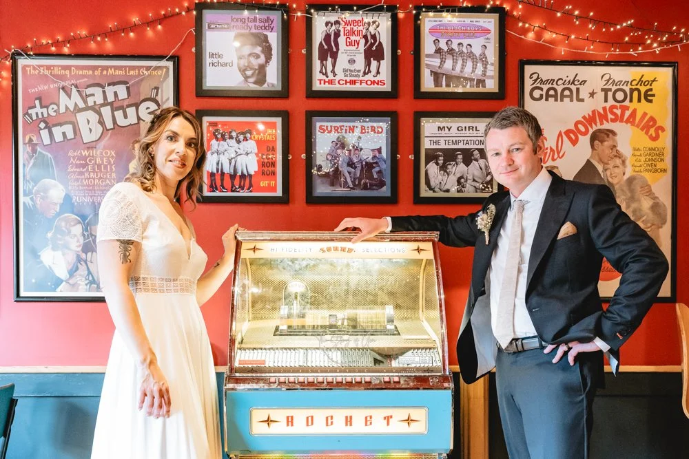 Wedding couple stood by Juke box