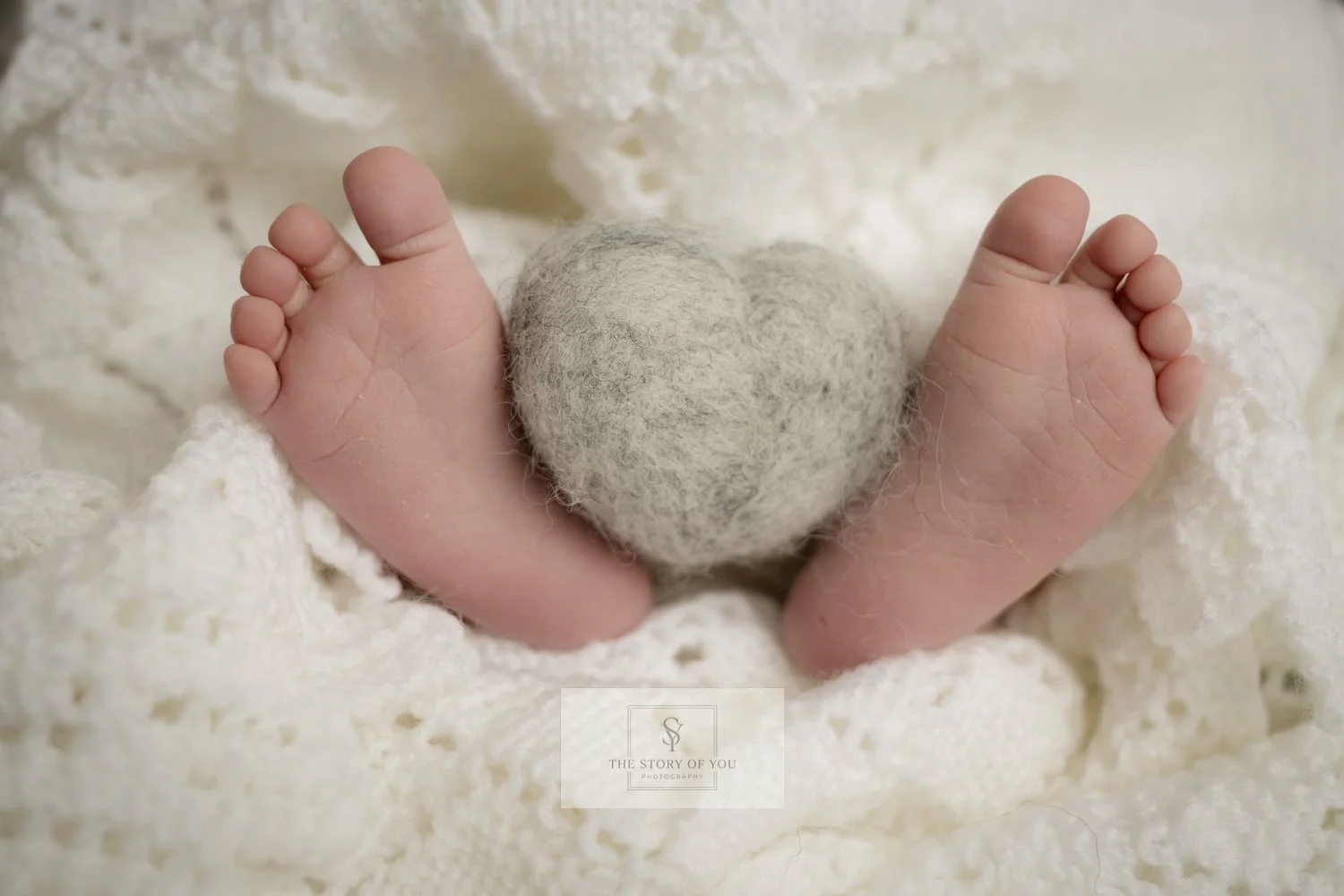 Newborn feet with love heart