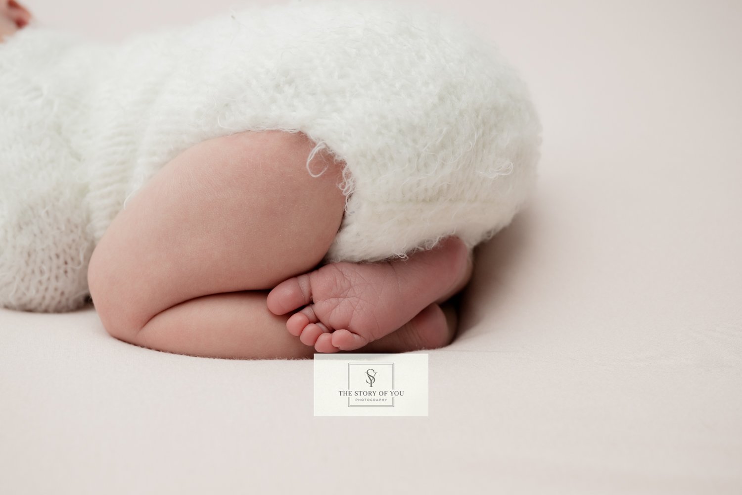 Newborn feet curled under a newborn
