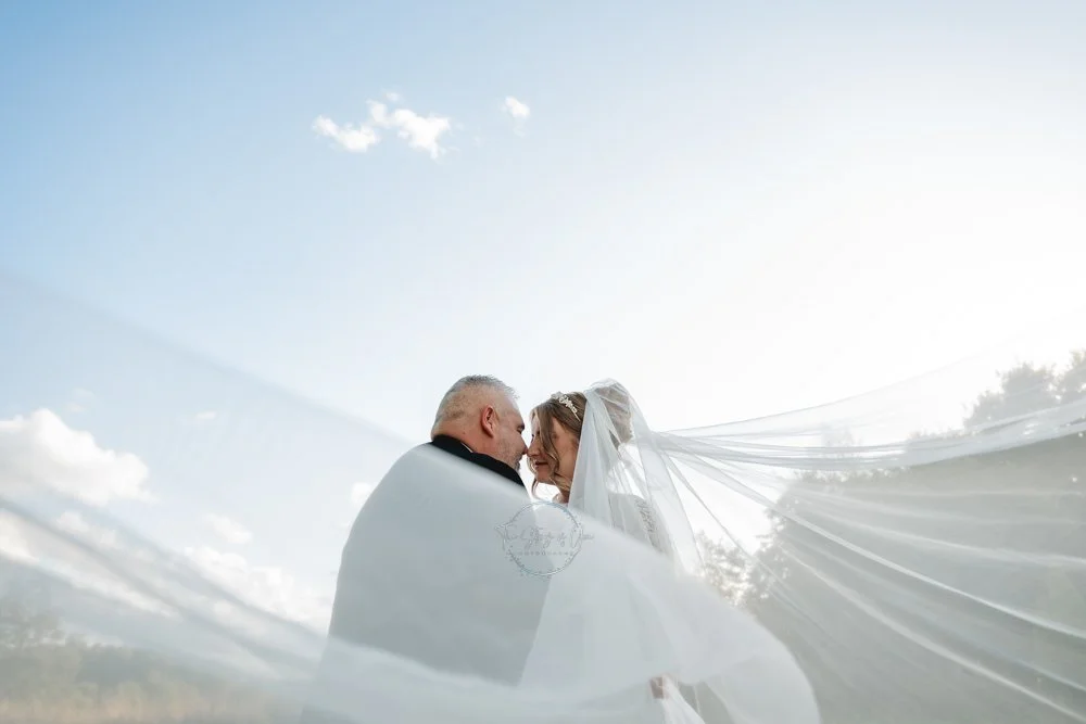 Bride and Groom with veil at Sunset