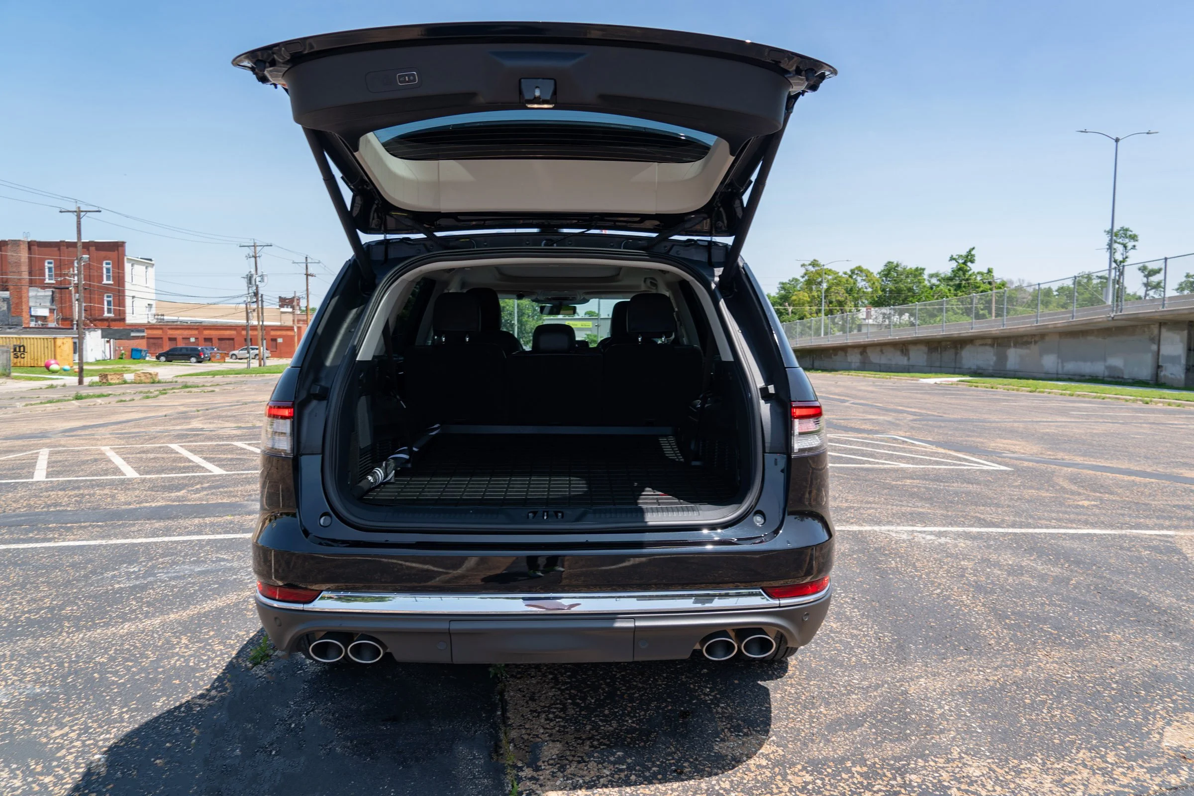 Black SUV with open trunk in empty parking lot, rear view
