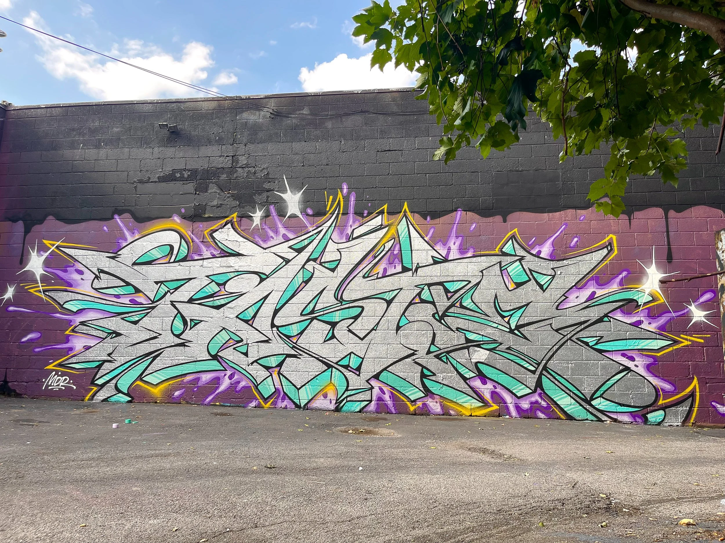 chrome graffiti burner on brick wall in parking lot