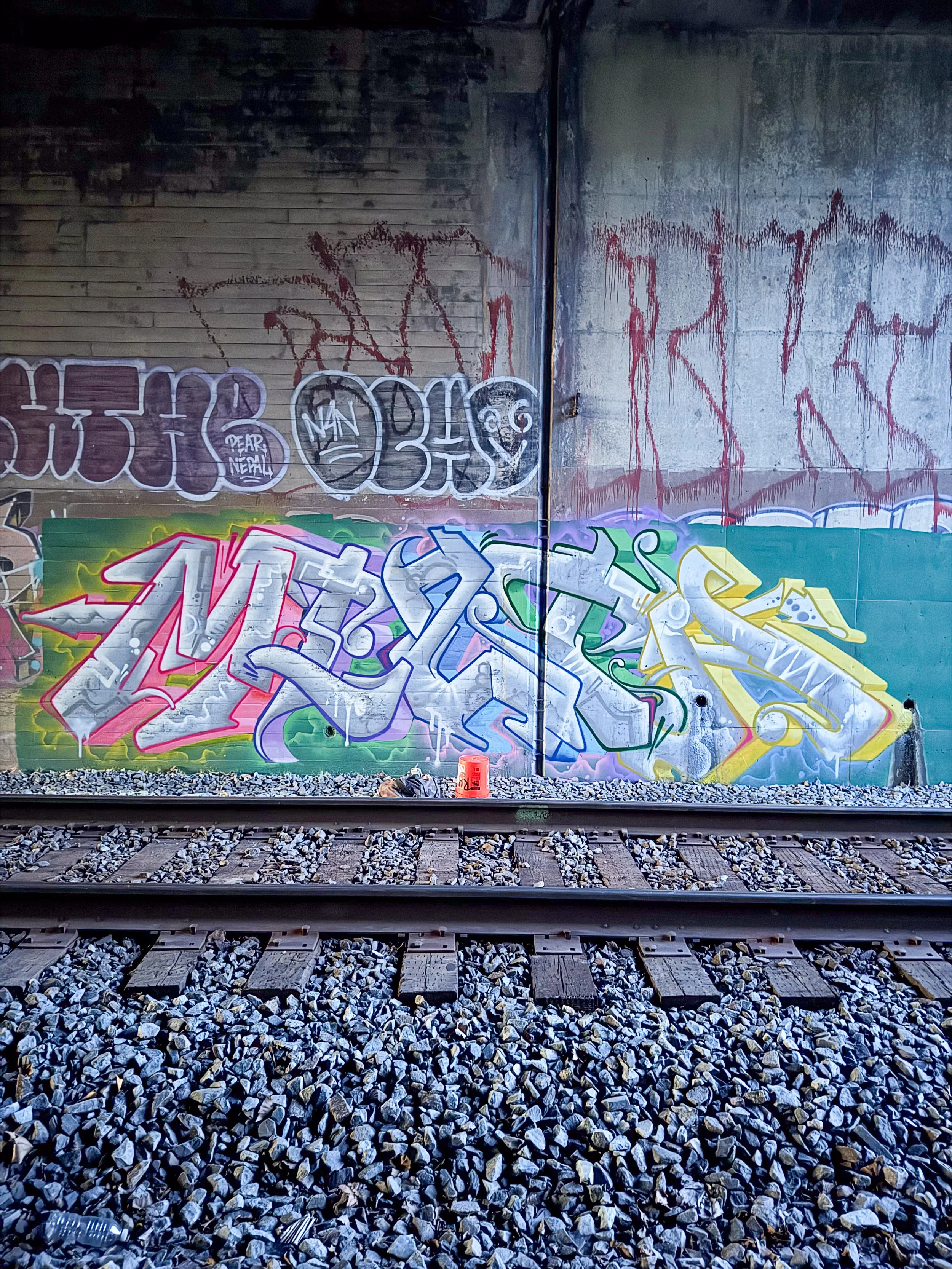 large graffiti art lettering mural on train tracks trackside graffiti art