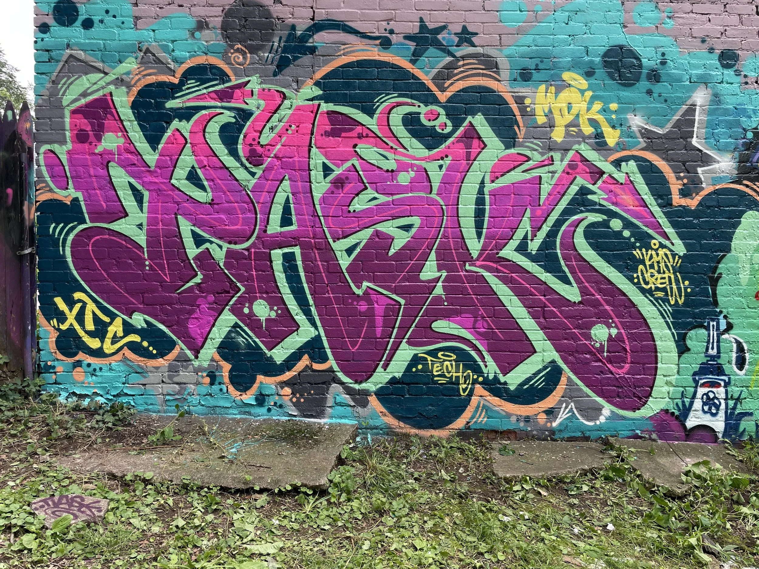 bold graffiti lettering mural art on brick wall of building