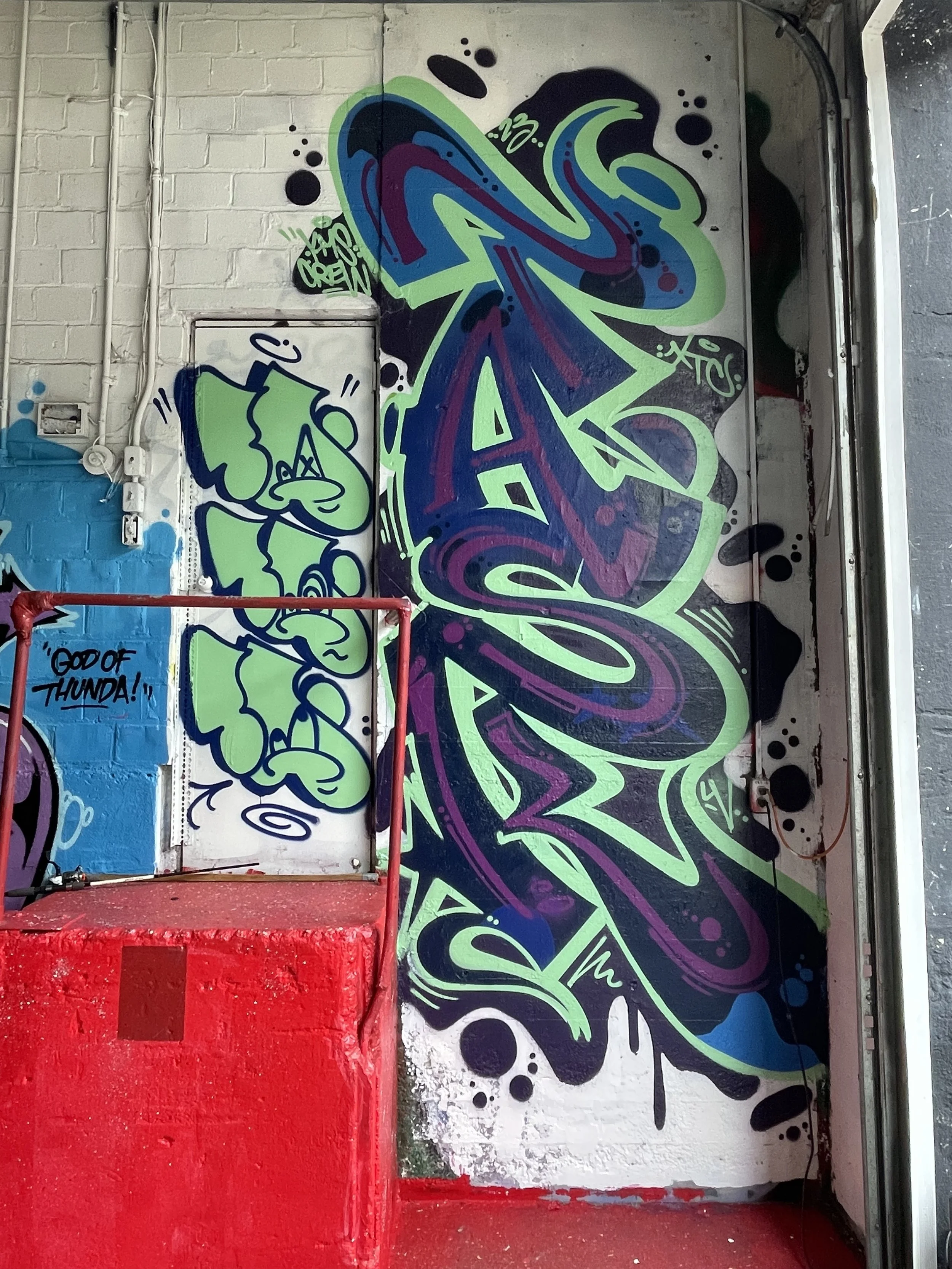 large graffiti mural inside abandoned building on concrete wall